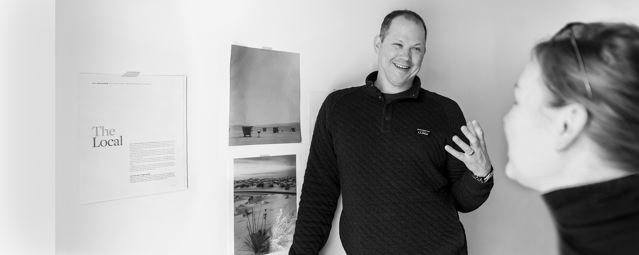zak in conversation with lauren in front of magazine pages taped to the wall